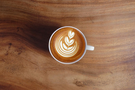 a cup of latte art coffee on wooden backgroundの写真素材