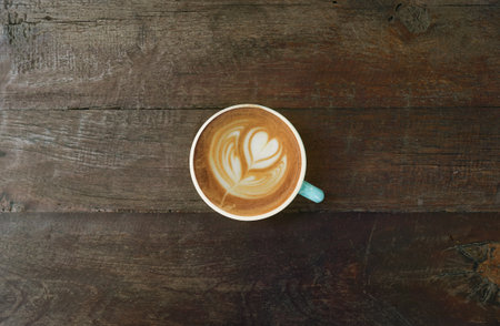 a cup of latte art coffee on wooden backgroundの写真素材