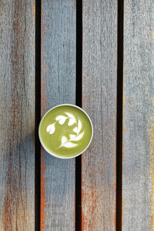 A cup of green tea matcha latte on wooden backgroundの写真素材