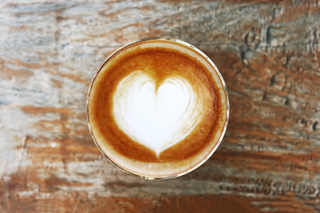 a cup of latte art coffee on wooden backgroundの写真素材