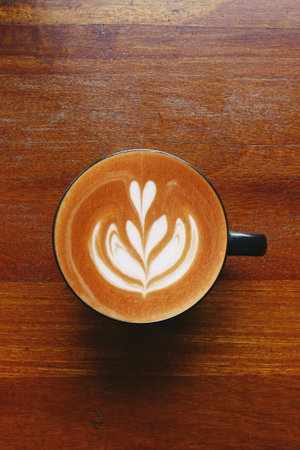 a cup of latte art coffee on wooden backgroundの写真素材