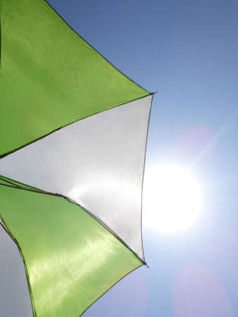 green and white umbrella over blue skyの写真素材