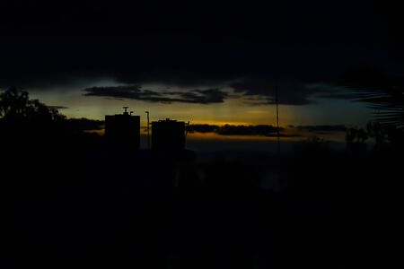 water tank silhouette with sun dawn skyの写真素材