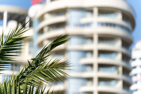 View of a fragment of the facade of a high-rise building with blue windows on a sunny day with a gray corner. Clouds are reflected in the windowsの写真素材