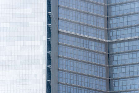 View of a fragment of the facade of a high-rise building with blue windows on a sunny day with a...