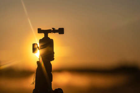 Beautiful view of the tripod silhouette in the rays of the rising morning sunの写真素材