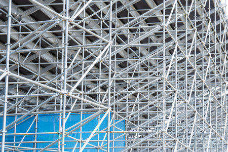 A forest of lightweight, reliable, metal tubular prefabricated supports on the back side of the stands at the stadium. The concept of reliability, elegance and safety in constructionの写真素材