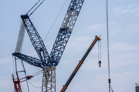 View of the boom of modern high cranes with cables and a hook. The concept of modern high-rise constructionの写真素材