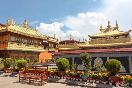Jokhang temple gplden roof in Lhasa, Tibet from distance with a benchの写真素材