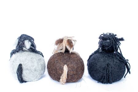 Three horses handmade of wool felt white, brown and black colors facing away