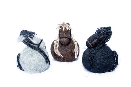 Three horses handmade of wool felt white, brown and black colors in a circle looking at each otherの写真素材