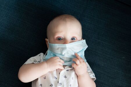 White caucasian baby boy in a face mask portrait touchingの写真素材