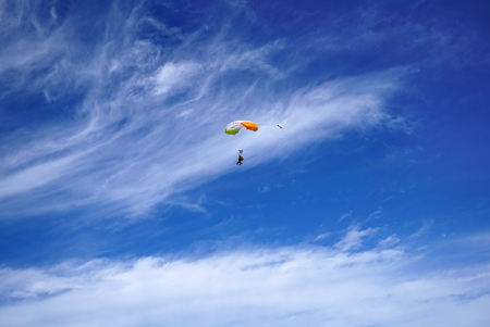 Bright white parachute canopy and tandem's skydivers against the background of unusual beautiful...