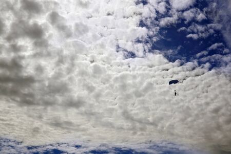 Parachute tandem canopy with skydivers against the gorgeous sky. Tandem is flying opposite beautiful...