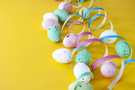 Colorful eggs, serpentine on yellow background, easter holiday party decoration.