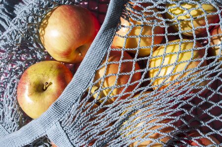 Farm apples in grey knitted bag, healthy fruits, Eco friendly, zero waste, Fair shopping, store.の写真素材