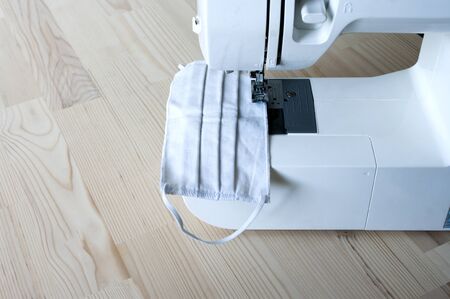 Hand made medicine mask on sewing machine, hand made, protection against virus, allergy. Close up.