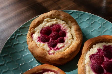 Small cake with cream cheese and raspberry on top, fresh baked, breakfast idea. Recipe for...