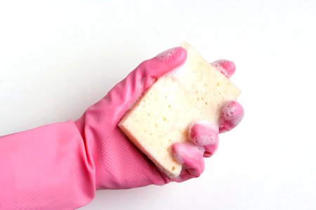 Hand in a pink rubber glove holding a sponge, isolated on white.