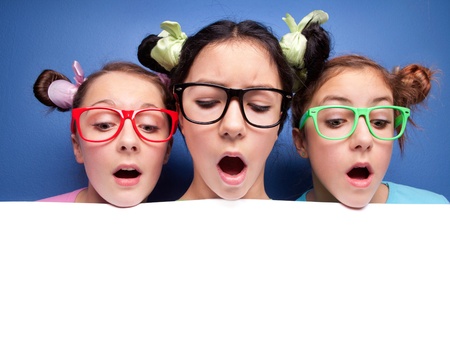 Three amazed teens with blank presentation boardの写真素材