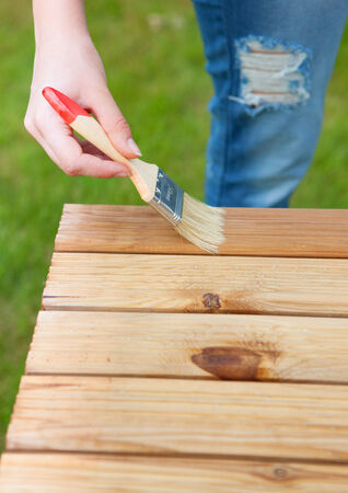 Hand with brush on a wooden background の写真素材