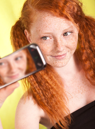 Freckled girl is taking a self portraitの写真素材