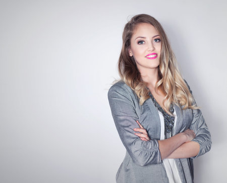 Young attractive friendly smiling professional business woman with arms crossed