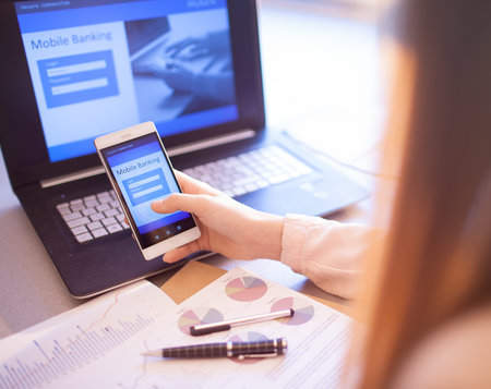 Close up of woman hand using online banking on mobile phone logging in to a bank account password...