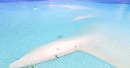 We are standing on a Maldives Island Indian Ocean sandbank, jet ski wake boarding at the background,...