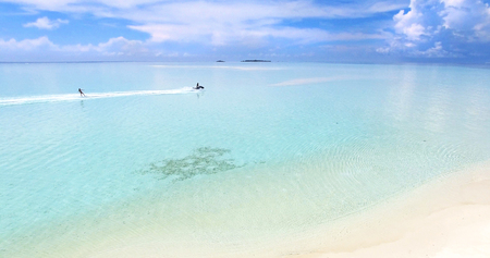 Maldives island Indian Ocean jet ski wakeboarding aerial top view. Turquoise water white sandy beachの写真素材