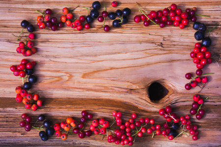 frame from different berries on a wooden table 