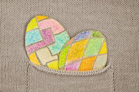 painted colorful Easter eggs in a knitted jacket pocket.