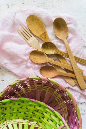 Wooden spoons and wicker baskets and white vintage background. Flat lay, top view, copy space.の写真素材