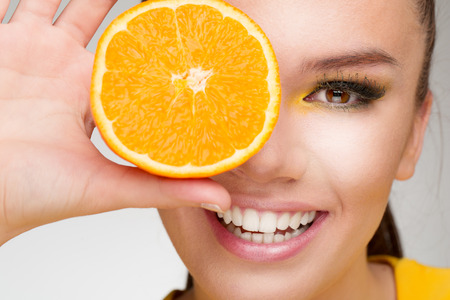 Young brunette with orange in her handの写真素材