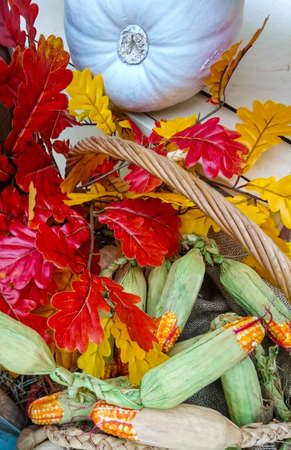 Yellow-orange pumpkins and bright flowers at home for Halloween on a haystack, straw, on a shelf. sunny day.の写真素材