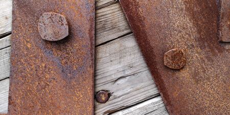 Close up texture of rusty iron sheets bolted to aged wooden planks in grayish-brown tone.Brutal wallpaper,backgroundの写真素材