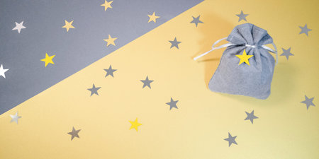 Gray felt gift bag on diagonal yellow gray, silver gold stars.Colors of the year 2021 ultimate gray,...
