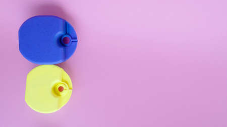 Closeup of new blue and yellow boxes,holders,for orthodontic devices for kids,children,teenagers for lip bumpers,aligner,dental plate and caps,used before and during braces on pink backdrop,copy spaceの写真素材