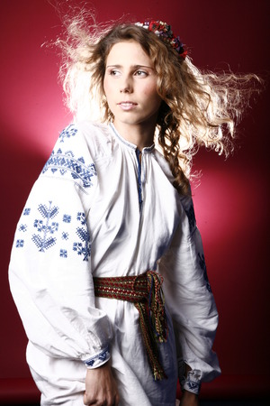 photo in ethnic clothes. The image of a young girl in a shirt that is embroidered with blue threads.の写真素材