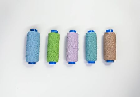 Colored sewing threads in pastel colors on a white background, top viewの写真素材