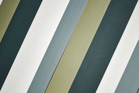 Background with diagonal stripes of beige, white and gray. The walls are made of smooth wooden boards of different colors. Wallpaper on the wall, wallpaper.の写真素材