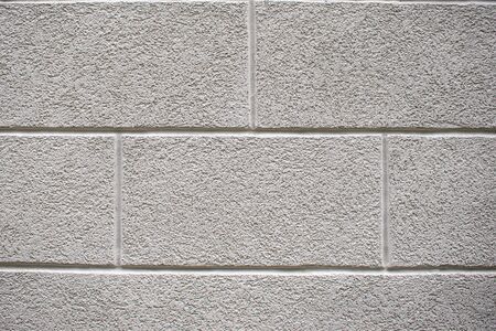 Texture of rough gray stucco wall. The walls are covered with cement decorative plaster. Large blocks are covered with decorative plaster. Background for the site, design. Space for textの写真素材