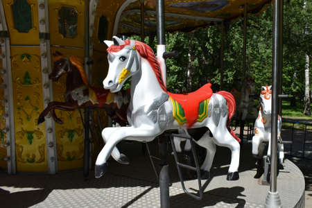 Old attraction, carousel with horses. Indoor park during a pandemic. An empty park without people with abandoned carousels. Closed fair with empty ridesの写真素材