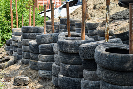 Warehouse for old used car tires. The tires are stacked vertically on metal beams. The problem of...