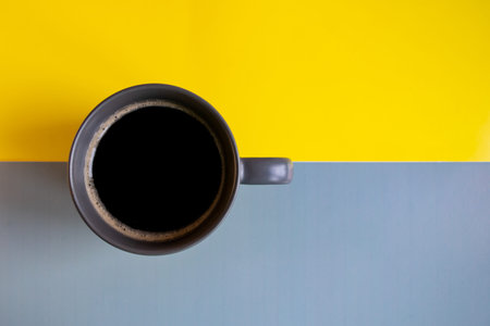 A cup of black coffee on a gray-yellow background. Concept: Good morning, energy boost, motivation....