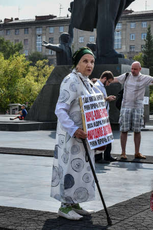 Novosibirsk, Russia - 08.08.2020: An elderly woman took to a solo picket against the government. On the poster is the inscription "People-Power of Russia".のeditorial素材