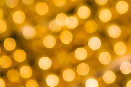 Gold bokeh background. Texture with shining blurred lights in yellow. Abstract christmas festive backgroundの写真素材
