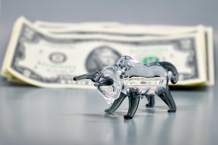 Glass figurine of a bull on a background of US dollars. Concept: business, stock exchange, finance,...
