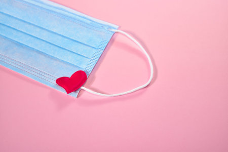 Red heart and medical mask. Medical mask on pink background. Gratitude to medical professionals...