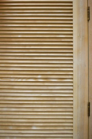 Wooden shutters. Window with wooden doors to protect from sunlight. Background with textured narrow boards. Modern shutters made of natural wood. Horizontal planks textureの写真素材